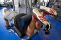 Man flexing leg muscles on gym machine Royalty Free Stock Photo