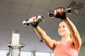 Sport, fitness, bodybuilding, teamwork and people concept - young woman flexing muscles on gym machine Royalty Free Stock Photo