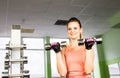 Sport, fitness, bodybuilding, teamwork and people concept - young woman flexing muscles on gym machine Royalty Free Stock Photo