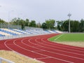Red treadmills, track running, green grass and empty stands at the stadium, on blue sky. Sport and fitness. Royalty Free Stock Photo