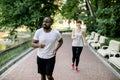 Sport fitness couple, young African man and Caucasian woman jogging outdoor in nature , at city park road. Two runners Royalty Free Stock Photo