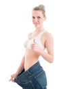 Sport, fitness and diet concept - close up of trained body of perfect smiling woman with big old jeans