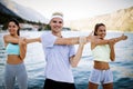 Group of happy people exercising outdoor. Sport, fitness, friendship and healthy lifestyle concept