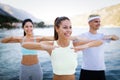 Group of happy people exercising outdoor. Sport, fitness, friendship and healthy lifestyle concept