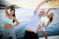 Group of happy people exercising outdoor. Sport, fitness, friendship and healthy lifestyle concept