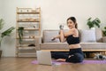 sport, fitness and healthy lifestyle concept - happy smiling young asian woman with laptop computer stretching arm at Royalty Free Stock Photo