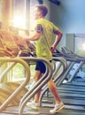 Man with smartphone exercising on treadmill in gym Royalty Free Stock Photo