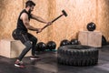 Sport Fitness Man Hitting Wheel Tire With Hammer Sledge Crossfit Training, Young Healthy Guy