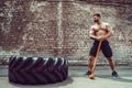 Sport Fitness Man Hitting Wheel Tire With Hammer Sledge Crossfit Training. Royalty Free Stock Photo