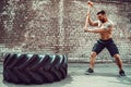 Sport Fitness Man Hitting Wheel Tire With Hammer Sledge Crossfit Training.