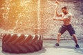 Sport Fitness Man Hitting Wheel Tire With Hammer Sledge Crossfit Training. Royalty Free Stock Photo