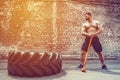 Sport Fitness Man Hitting Wheel Tire With Hammer Sledge Crossfit Training. Royalty Free Stock Photo