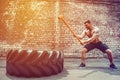 Sport Fitness Man Hitting Wheel Tire With Hammer Sledge Crossfit Training. Royalty Free Stock Photo