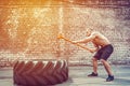 Sport Fitness Man Hitting Wheel Tire With Hammer Sledge Crossfit Training.