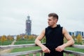 Sport fitness man posing against the backdrop of the city. Male athlete outside fall park. Fit model.