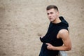 Sport fitness man posing on the beach. Male athlete outside fall park