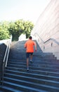 Sport, fitness - sportsman is running in the city, male runner on steps stairs