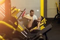 Young woman and personal trainer with flexing muscles in gym Royalty Free Stock Photo