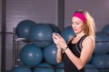 Sport, fitness, technology and people concept - young woman with activity tracker and smartphone in gym