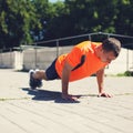 Sport, fitness and workout concept - sportsman doing push-ups