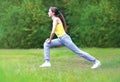 Sport, fitness and yoga concept - woman sportsman is doing stretching exercises on the grass