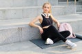 Sport and Fitness Young Adult Caucasian Woman Sitting Exercise Mat Concrete Floor Resting after morning Workout Outdoor Summer Royalty Free Stock Photo