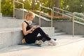 Sport and Fitness Young Adult Caucasian Woman Sitting Exercise Mat Concrete Floor Resting after morning Workout Outdoor Summer Royalty Free Stock Photo