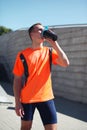 Sport, fitness - young runner man drinks from a bottle the water or a protein shake, male sportsman after training