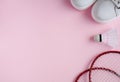 Sport flat lay with shuttlecock, two rackets for playing badminton and white sneakers on a pink background. Royalty Free Stock Photo