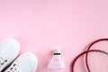 Sport flat lay with shuttlecock, two rackets for playing badminton and white sneakers on a pink background. Concept healthy Royalty Free Stock Photo