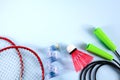 Sport flat lay with two rackets for playing badminton, shuttlecock, jump rope and measuring tape on a blue background. Concept Royalty Free Stock Photo