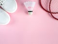 Sport flat lay with white sneakers ,shuttlecock and two rackets for playing badminton on a pink background. Royalty Free Stock Photo