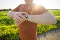 Sport, gadget, activity tracker and people concept - Close up of runner jogging outside looking at his wearable fitness