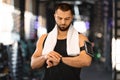 Sport Gadgets Concept. Muscular Male Athlete Checking His Smartwatch At Gym Royalty Free Stock Photo