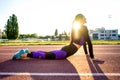 Sport girl engaged yoga in a warm-up at the stadium at sunset