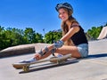 Sport girl with injury near her skateboard outdoor. Royalty Free Stock Photo