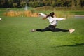 Sport girl jumping in the air on nature demonstrate perfect stretching. Royalty Free Stock Photo