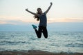 Sport girl jumping on beach at sunset. Royalty Free Stock Photo