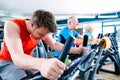 Sport in the gym - people spinning of fitness bikes Royalty Free Stock Photo