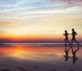 Runners on the beach, silhouette of people jogging at sunset, healthy lifestyle Royalty Free Stock Photo