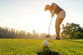 Sport Healthy. Golfer asian sporty woman focus putting golf ball on the green golf on sun set evening time. Royalty Free Stock Photo