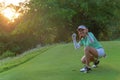Sport Healthy. Golfing game. Asian woman golfer action to win after long putting golf ball on the green golf, outdoors in vocation