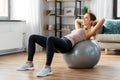 Happy woman exercising on fitness ball at home Royalty Free Stock Photo