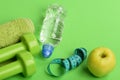 Dumbbells in green color, water bottle, measure tape and towel Royalty Free Stock Photo