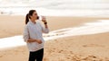 Sport and hydration. Young fit woman drinking mineral water from bottle, resting after training by seaside, copy space Royalty Free Stock Photo