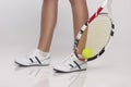 Sport Ideas. Legs of Caucasian Female Lawn Tennis Player Holding Green Tennis Ball With Raquette. Over White Royalty Free Stock Photo