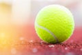 Sport Item concept : Tennis balls at red court in summer day. Tennis is racket sport that can be played individually against