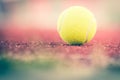 Sport Item concept : Tennis balls at red court in summer day. Tennis is racket sport that can be played individually against