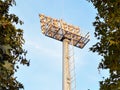 Sport lighting mast with powerful searchlights between trees