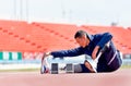 Sport man athlete with a prosthesis on his leg sit and action of stretching near running equipment on the track at the stadium. Royalty Free Stock Photo